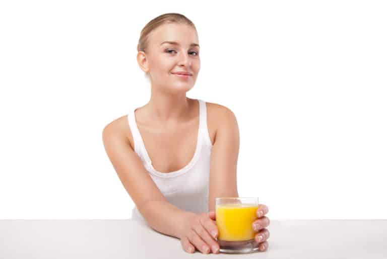 Billede af kvinde der drikker et glas appelsin juice.